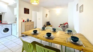 Un espacio habitable compacto con comedor, lavadora y kitchenette.