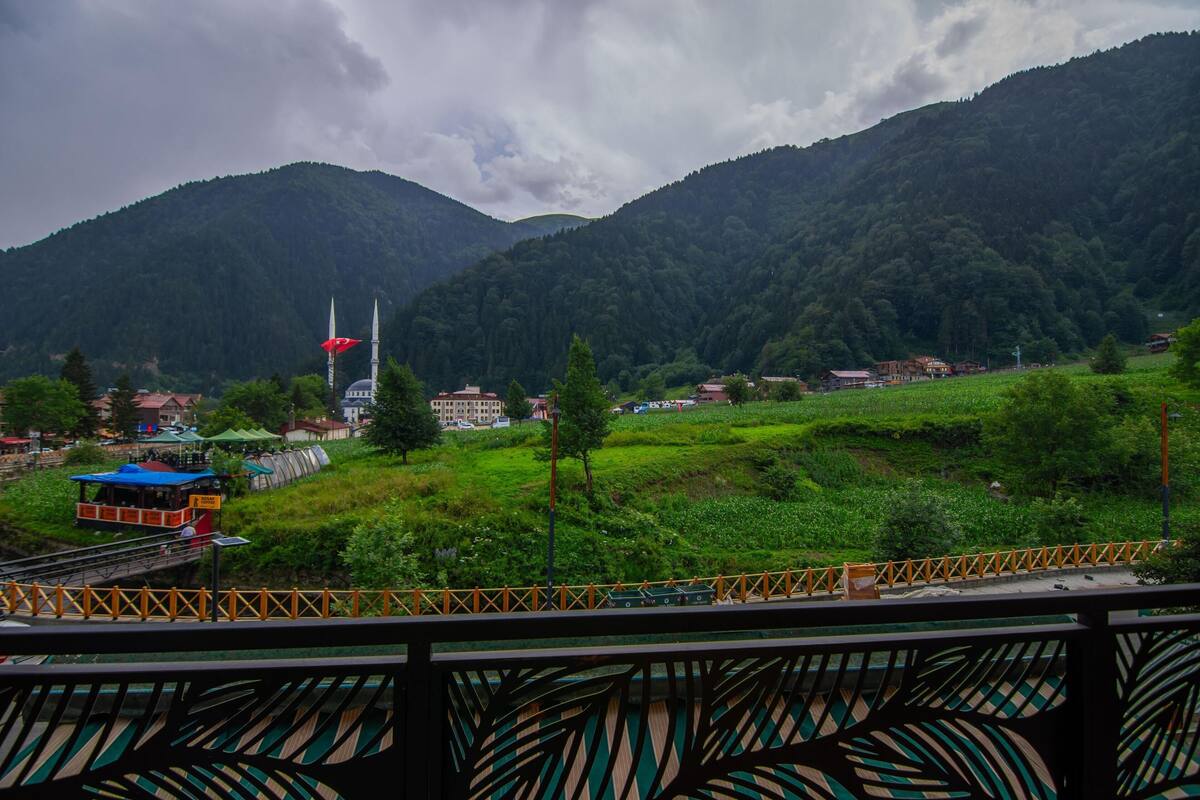 A mountainous landscape with a mosque, a bridge, and a small settlement.