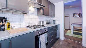 Una cocina moderna con estufa a gas, microondas y armarios de acero inoxidable.
