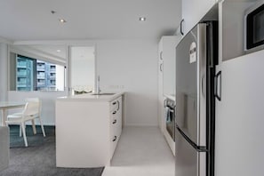 Una cocina moderna con una isla central, horno empotrado y refrigerador.