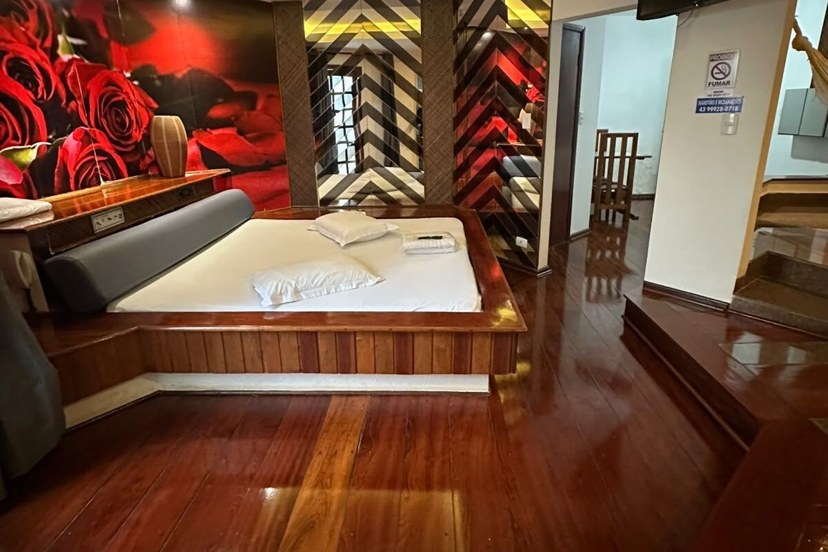 A modern bedroom with a large bed, a seating area, and a wall with a geometric pattern.
