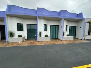 Un edificio moderno con techo plano, puertas de vidrio grandes y paredes blancas.