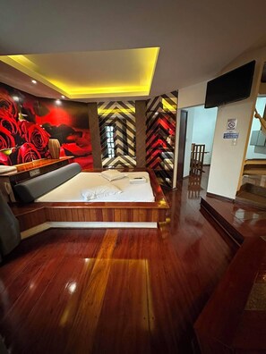 A modern bedroom with a large bed, a seating area, and a decorative wall with geometric patterns. - Johnnys Motel-Hotel (Cornélio Procópio)