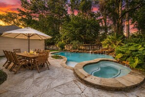 A backyard with a swimming pool, hot tub, patio table, and chairs. - Luxury Woodlands Home w Pool, Spa & ample TV Room. Best location & Fun for all!! (Spring)