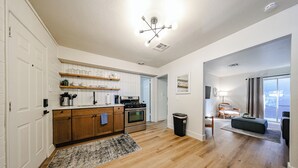 A modern kitchen with wooden cabinets, a built-in oven, and a countertop with kitchenware.