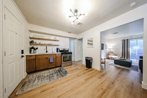 Eine moderne Küche mit Holzausstattung, einem Einbauofen und einer Arbeitsplatte mit Küchenutensilien.