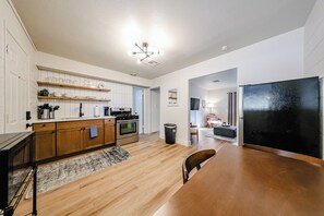 Eine moderne Küche mit Holzausstattung, einem eingebauten Backofen und einem schwarzen Kühlschrank.