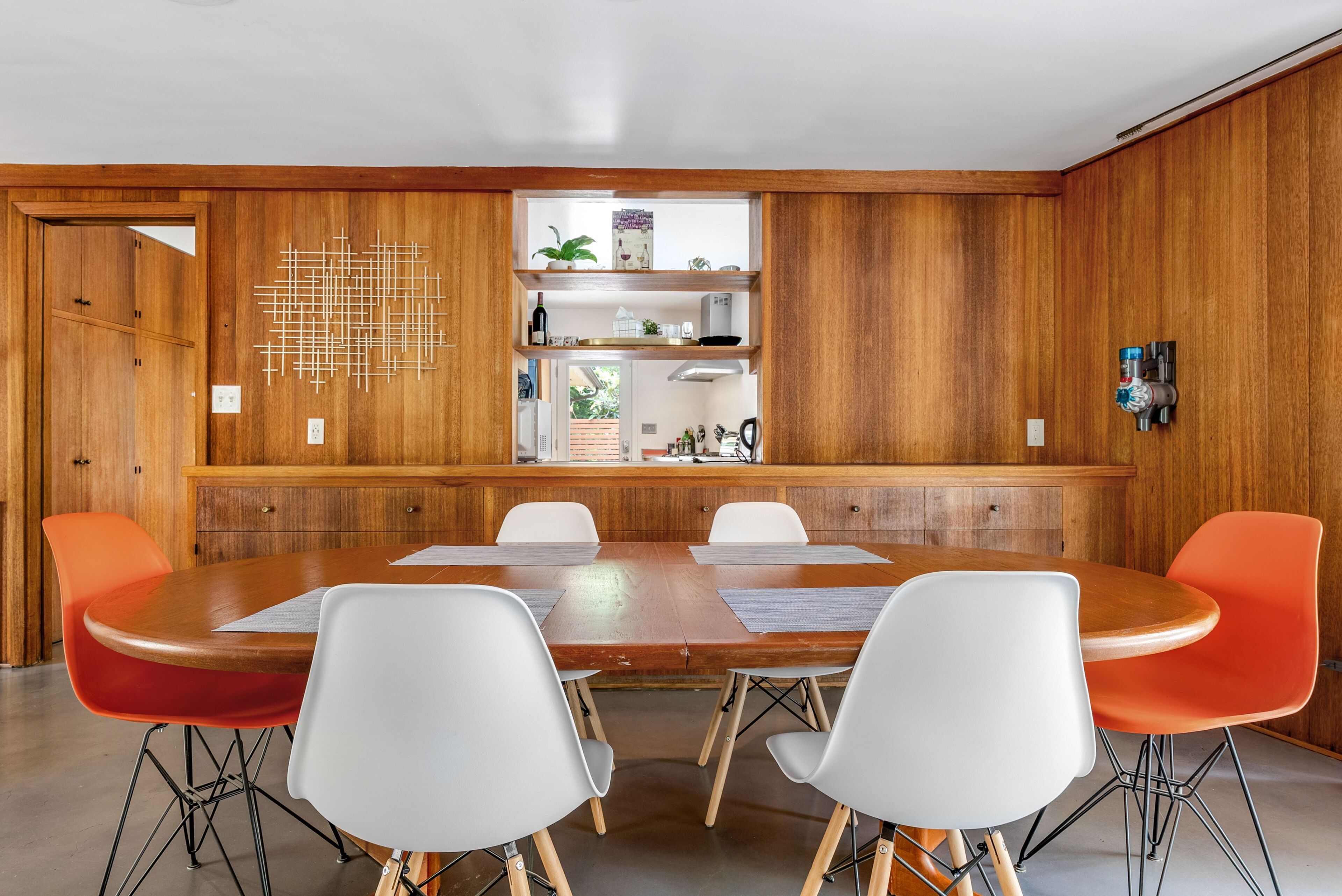 A conference room with a wooden panel wall, a central table, and four chairs.