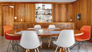 Una sala de conferencias con pared de madera, una mesa central y cuatro sillas.