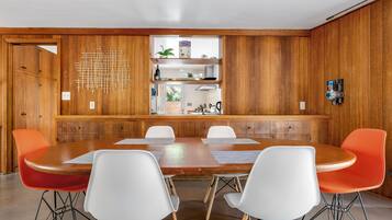 A conference room with a wooden panel wall, a central table, and four chairs.