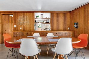 A conference room with a wooden panel wall, a central table, and four chairs. - Serene Home Near Rose Bowl with Hot Tub (Pasadena)