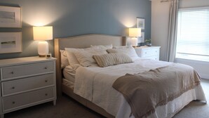 Una camera da letto con un letto, comodini e lampade a parete.