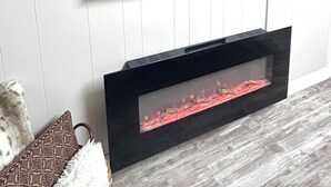 A flat-screen TV mounted on a wall above a fireplace. - Lakeview 1BR/1BA guest suite, pickleball, fishing, close to Asheville & BRP. (Weaverville)