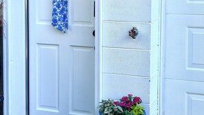 A white door with a wreath, a wooden mailbox with the number 8 1/2, and a blue planter with flowers. - Lakeview 1BR/1BA guest suite, pickleball, fishing, close to Asheville & BRP. (Weaverville)