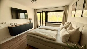 Una camera da letto con un letto, una TV, una finestra e un armadio.