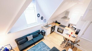 A compact living space with a loft bedroom, kitchenette, and a dining area. - Elegant Cardiff Bay Flat Spacious & Comfortable (Cardiff)