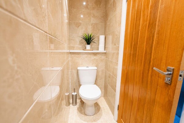 A bathroom with a toilet, a sink, and a shower area.