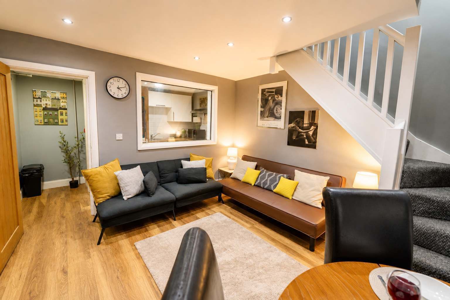 En moderne stue med sofa, sofabord og trappe.