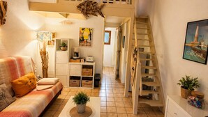 A cozy living area with a sofa, coffee table, and a staircase leading to an upper level.