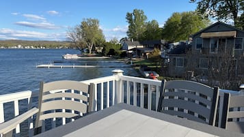 Une terrasse au bord de l’eau offrant une vue sur un lac, un quai et des immeubles résidentiels.