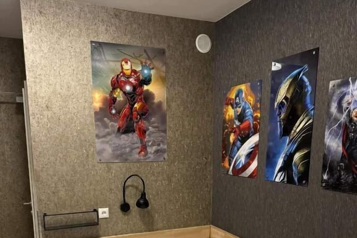 A bedroom with a wooden bed, a headboard, and a wall with three posters.