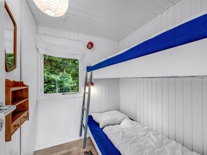 Habitación con literas, una ventana, una escalera y un estante con zapatos.