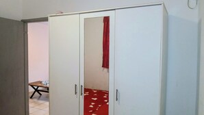 A room with a white wardrobe, a red curtain, and a tiled floor. - THE MILANOSIMPLY (Kourou)