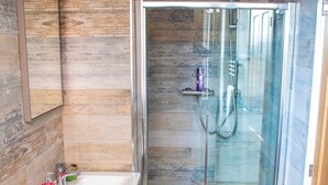 A modern bathroom with a glass-enclosed shower, a standalone bathtub, and a vanity with a mirror. - Stylish Comfort in the Heart of Sheffield (Sheffield)