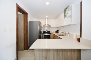 A modern kitchen with a central island, stainless steel appliances, and white cabinetry. - Perfect 3-bedroom condo on 3rd level with elevator in Los Corales
Navio II A-301 (Los corales)