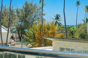 A view of a building with a pool, surrounded by trees and a clear sky. - Perfect 3-bedroom condo on 3rd level with elevator in Los Corales
Navio II A-301 (Los corales)