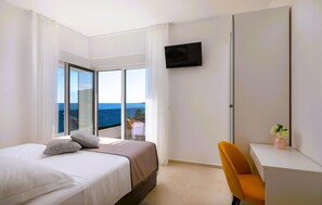 A hotel room with a bed, a desk, a chair, a TV, and a balcony with a view of the sea. - Awesome home in Sevid (Sevid)
