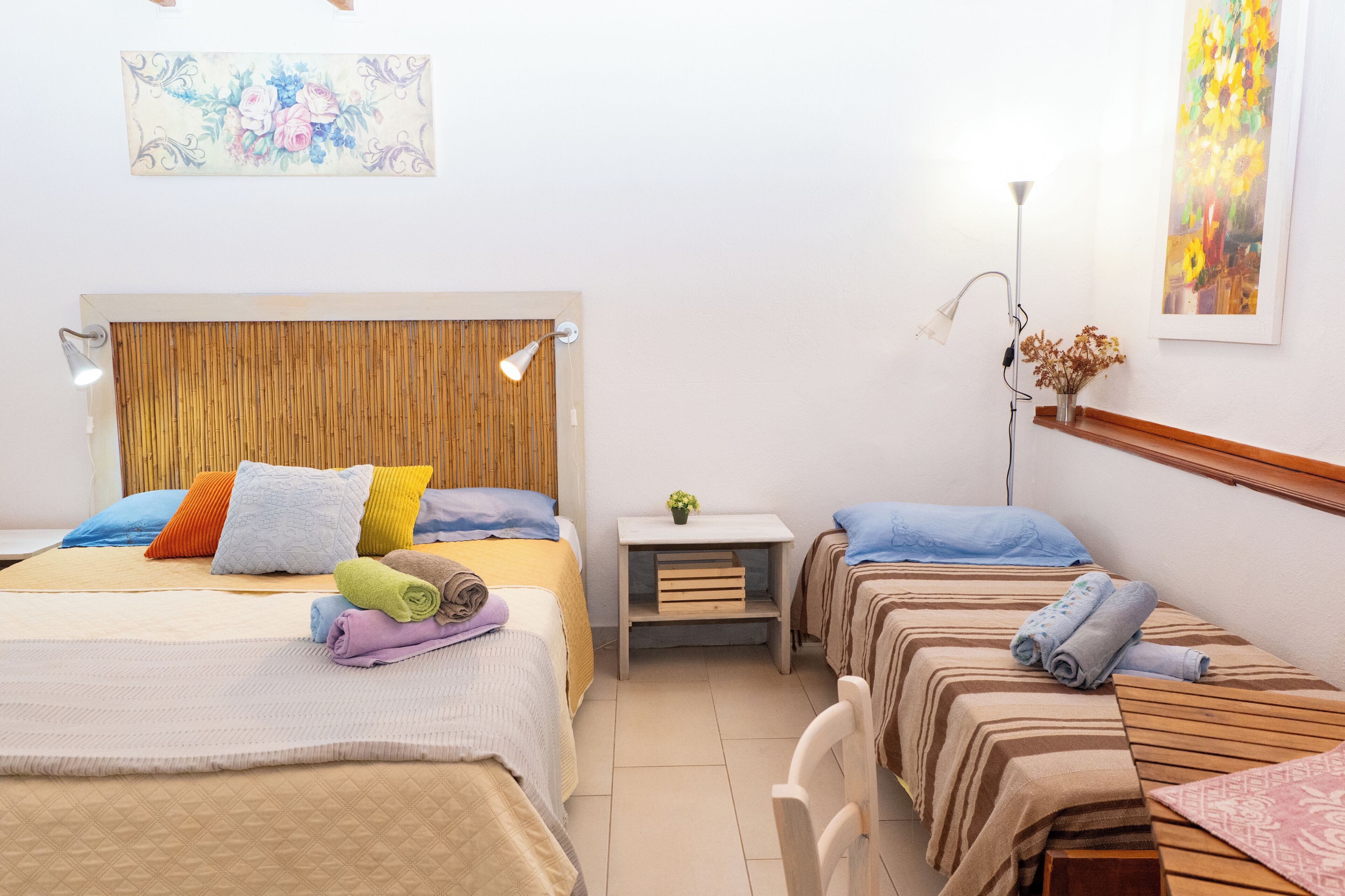 Habitació d'hotel amb llit, una taula de nit, una làmpada i un quadre a la paret.