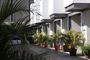 A modern building with a series of balconies, potted plants, and a clear pathway. - Hotel Robussta (Sayulita)