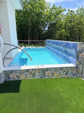 Una piscina amb una profunditat de 1,8 metres, envoltada per una paret decorativa i una zona de seguretat de 1,2 metres.