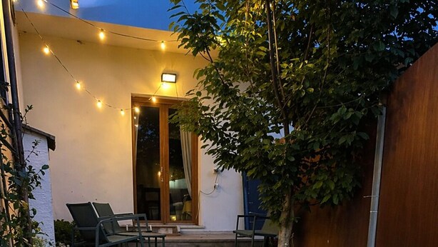 A stone pathway leading to a patio with outdoor furniture and string lights. - Su Entu Suite Free Parking 5 min from the sea (Giba)