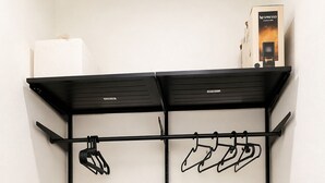 A black metal wardrobe with two shelves, a hanging rod, and a shoe rack. - Su Entu Suite Free Parking 5 min from the sea (Giba)