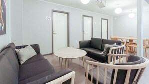 Ein modernes Interieur mit einer Couch, Stühlen, einem runden Tisch und Türen mit den Nummern 09, 10 und 11.