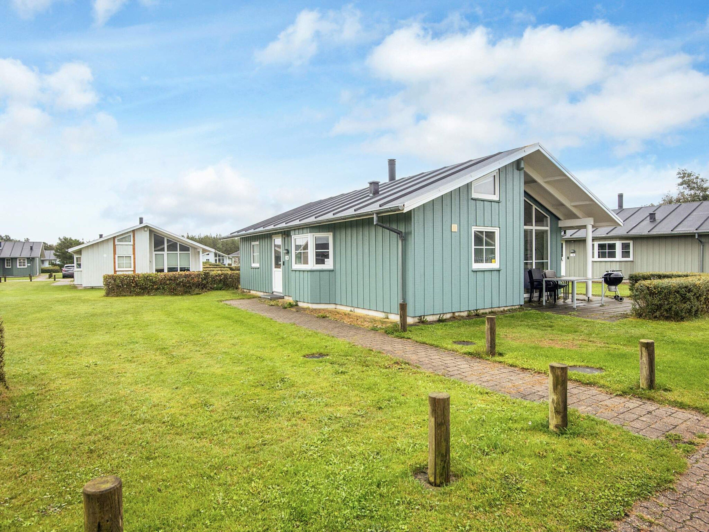A row of single-story houses with a paved walkway in between.