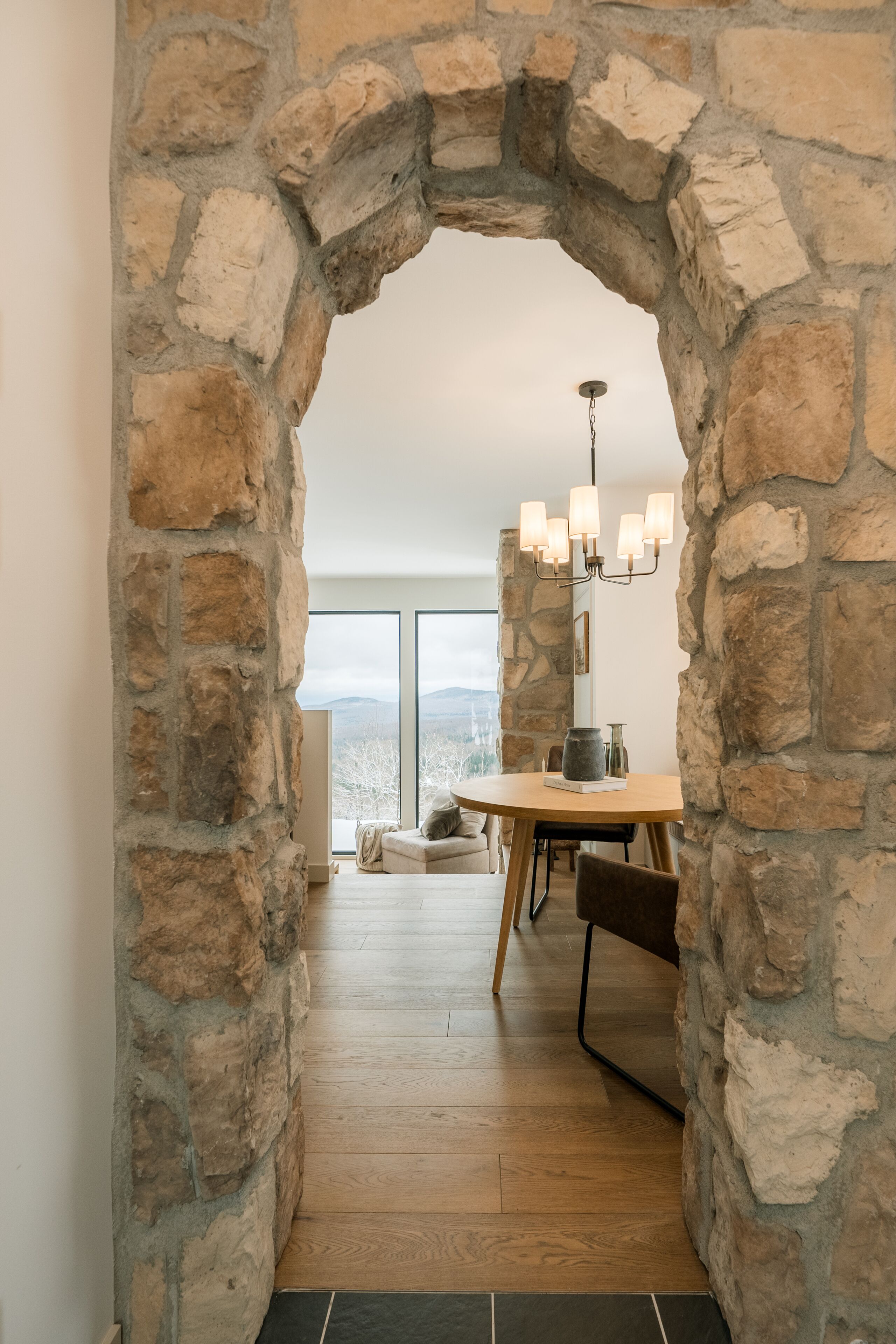 A stone archway leading to a dining area with a view of the outdoors.. Chalet le rifugio with spa and mountain views