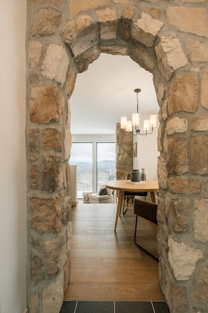 A stone archway leading to a dining area with a view of the outdoors.. Chalet le rifugio with spa and mountain views