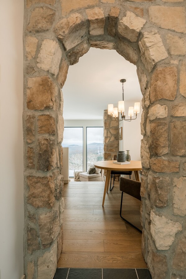 A stone archway leading to a dining area with a view of the outdoors.