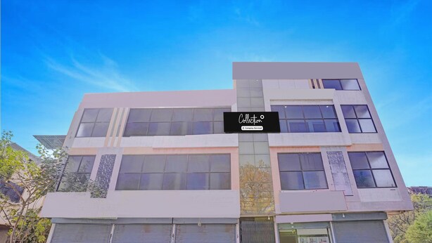 A modern building with a sign reading 'Collection & Company Services' and multiple closed shutters at the ground level. - Collection O Iskcon Aurangabad (Chhatrapati Sambhajinagar)