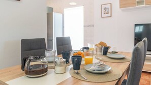 A breakfast table set with coffee, juice, and pastries in a modern kitchen with grey chairs and a TV in the background. - Villa Los Labrados Sayalonga by Ruralidays (Málaga)