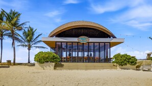 A beachside building with a curved roof, a sign reading 'Wahaca's Bar,' and outdoor seating. - Luxury Oceanfront Apartment - Playa Escondida 503 (Portobelo)