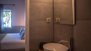 Ein Schlafzimmer mit Bett, Nachttisch und einem fenster mit Vorhängen.
