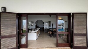 A room with a bed, a dining table, and chairs. - TP Maria Luisa dos Olhos Villa - Private Pool and Beach (Olhos de Água)