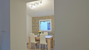 Ein Essbereich mit Tisch und Stühlen, einem Fenster und einer Lampe.