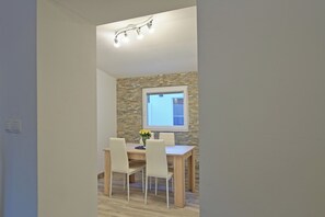 A dining area with a table and chairs, a window, and a light fixture. - Vacation home with private wellness area and fenced garden in a quiet location. (Brinje)