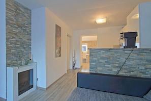 A modern living room with a fireplace, a stone accent wall, and a seating area. - Vacation home with private wellness area and fenced garden in a quiet location. (Brinje)