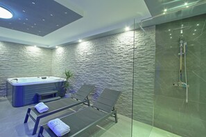 A modern spa room with a hot tub, two lounge chairs, and a glass-enclosed shower area. - Vacation home with private wellness area and fenced garden in a quiet location. (Brinje)